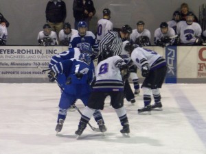 Bison Hockey team watches as Senior Alec Ackmann takes the faceoff.  Photo by Lauren Rosso