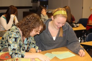 Ashley Anderson and Caitlin Theisen look over information about Students Stepping Up