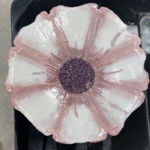 A bowl in the shape of a pink and white flower, with a purple center