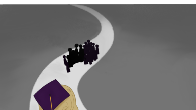A senior dressed for graduation in a purple cap and gown watches a cluster of graduates in the distance.