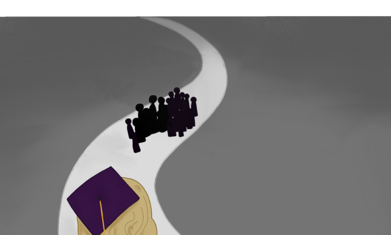 A senior dressed for graduation in a purple cap and gown watches a cluster of graduates in the distance.