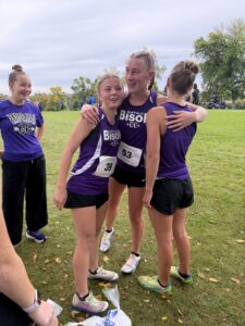 Cross country team congratulates Macheel after race.