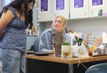Math Teacher Reese Wishart checks in with a student during class