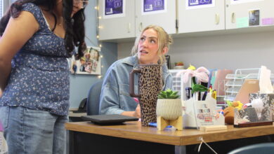 Math Teacher Reese Wishart checks in with a student during class
