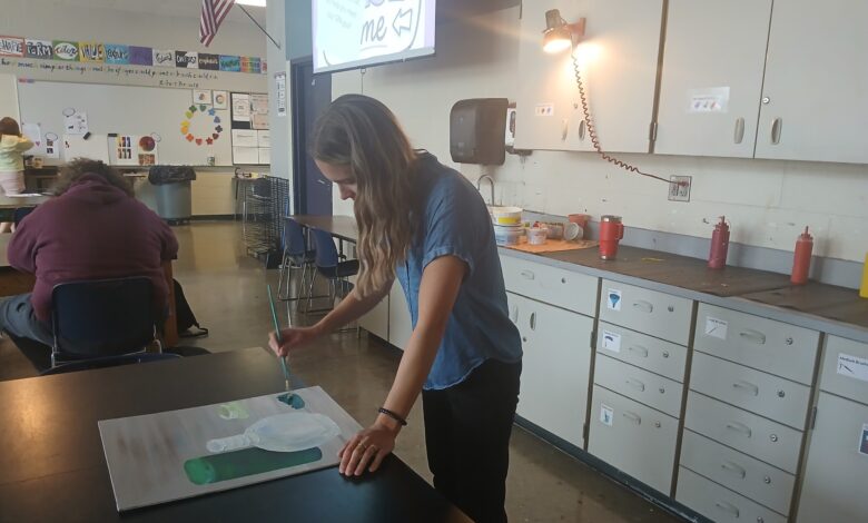Art teacher Jillian Post paints on a canvas