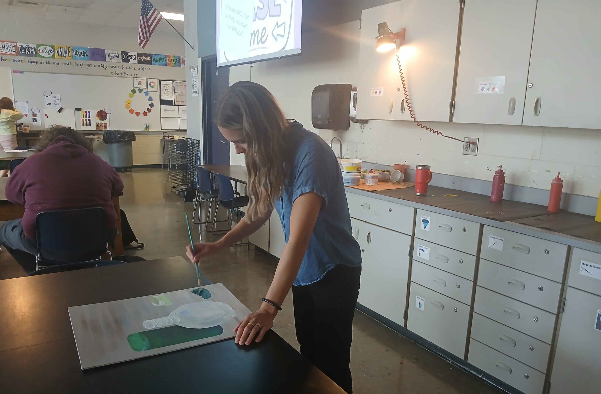 Art teacher Jillian Post paints on a canvas