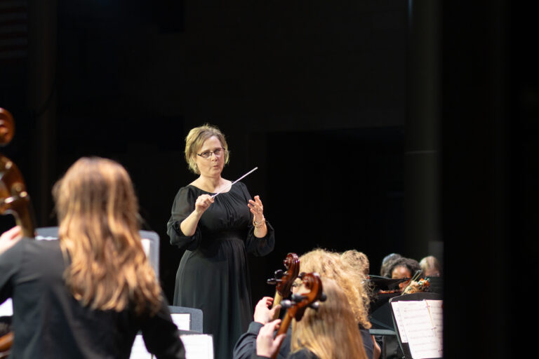 Orchestra teacher Kristine Weise conducts at the first orchestra concert of the year