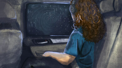 A girl wearing headphones looks out a car window form the back seat during a nighttime drive.