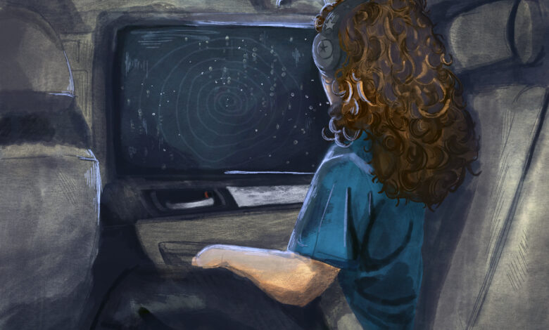 A girl wearing headphones looks out a car window form the back seat during a nighttime drive.