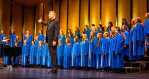 Zach Carlson-Giving presents the Reparatory Choir to the audience at the conclusion of their segment of the concert. 