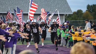 BHS boys football running on the field to begin the game